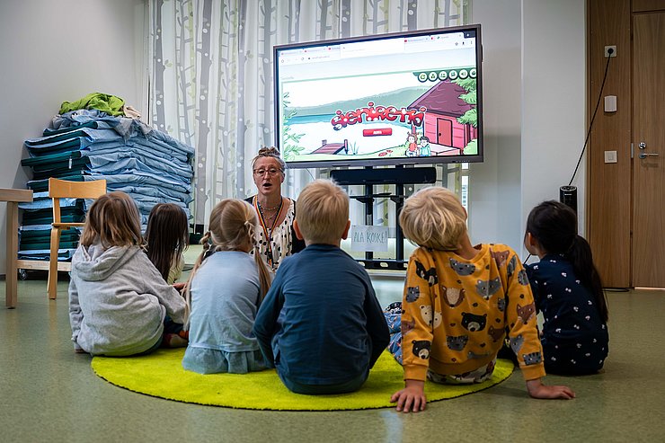 © Land Tirol/Christanell Betreuerin und Kinder auf Boden sitzend spielen