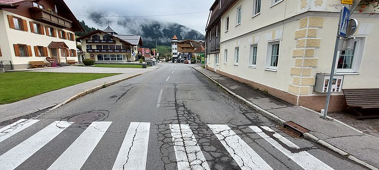 © Land Tirol/BBA Reutte Foto einer beschädigten Straße mit Zebrastreifen und Gehsteig im Orstkern