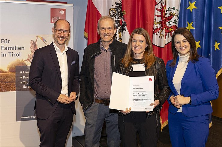 vier Personen mit Urkunde