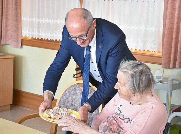 LH Mattle bringt Bewohnerin Teller mit Waffeln an den Tisch