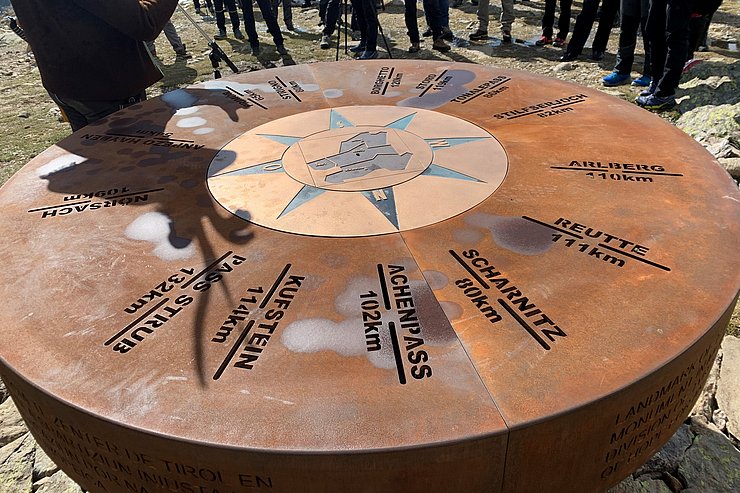 © Tiroler Landtag Der Markstein am Latzfonser Kreuz zeigt die Entfernungen zu den Außengrenzen des historischen Tirols und wurde u.a. von der Innsbrucker Glockengießerei Grassmayr realisiert.