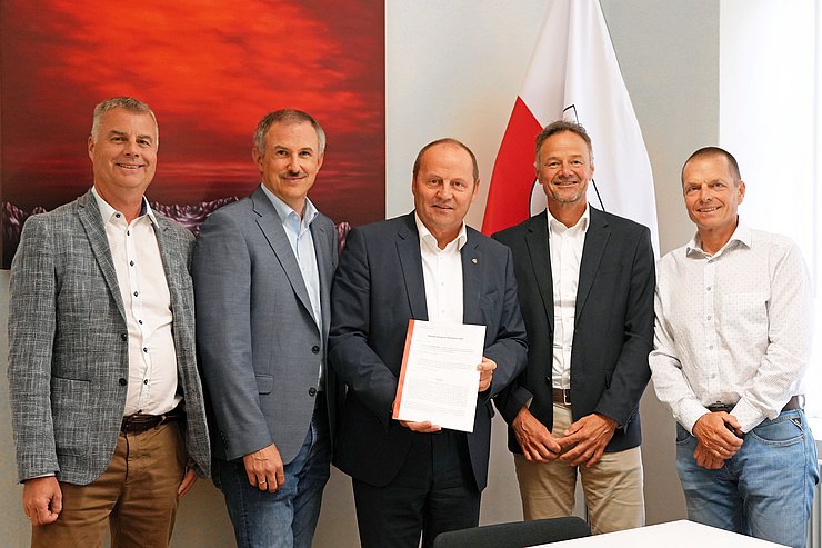 Mehrere Menschen posieren für ein Gruppenbild.