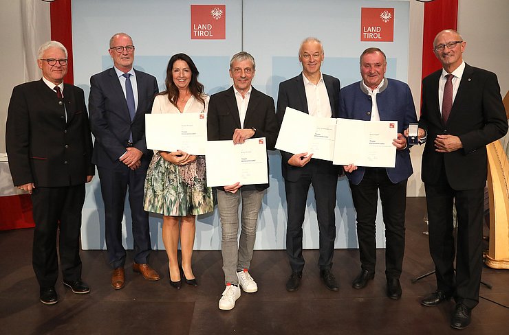 BH Siegmund Geiger, Bürgermeister von Ischgl Werner Kurz und LH Anton Mattle mit den Geehrten der Gemeinde Ischgl