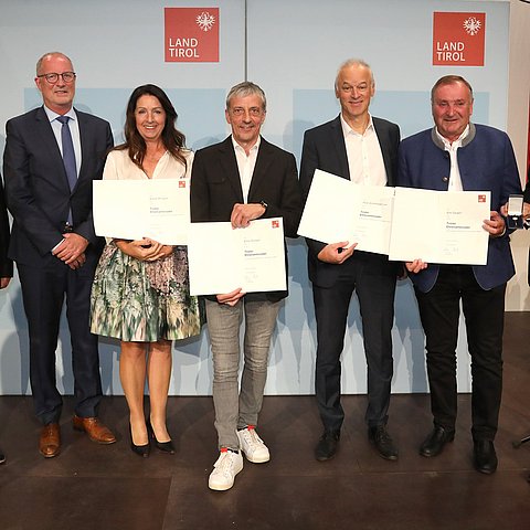 BH Siegmund Geiger, Bürgermeister von Ischgl Werner Kurz und LH Anton Mattle mit den Geehrten der Gemeinde Ischgl