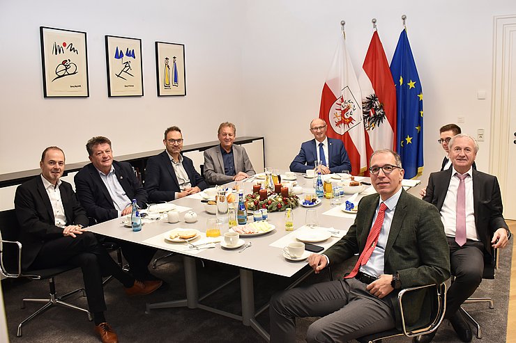 Vertreter der Sozialpartner sitzen an einem Tisch und frühstücken