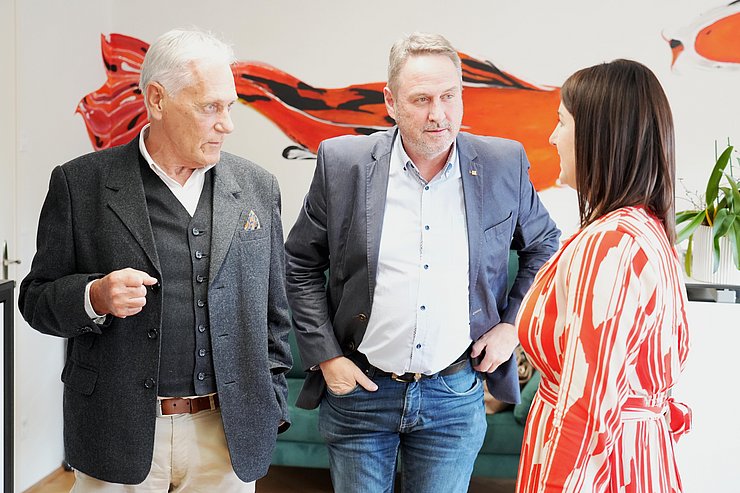 © Land Tirol/Neuner Zwei Männer unterhalten sich mit einer Frau.