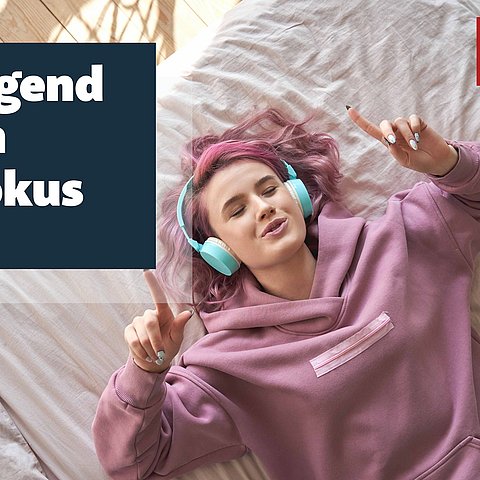 Sujet: Jugendliche liegt im Bett und hat Kopfhörer auf; Text "Jugend im Fokus"