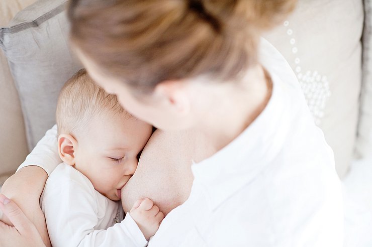 © jfk image/Shutterstock.com Mutter stillt Baby