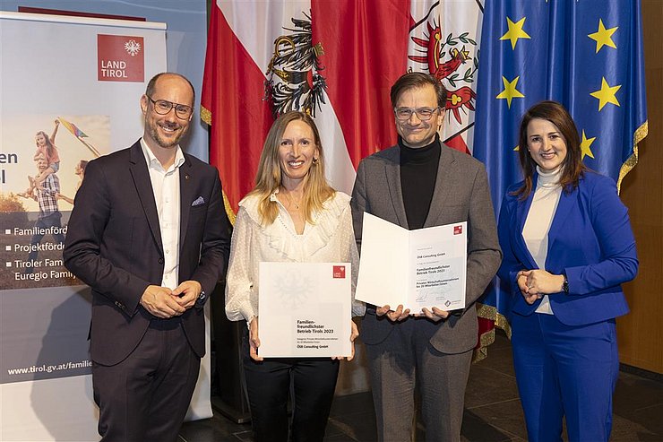 vier Personen mit Urkunde