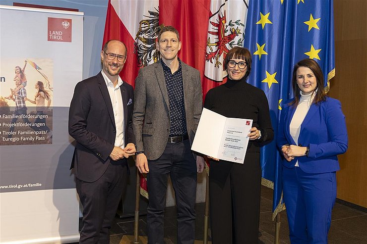 vier Personen mit Urkunde