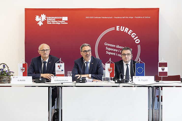 Personen sitzen nebeneinander, LH Kompatscher spricht