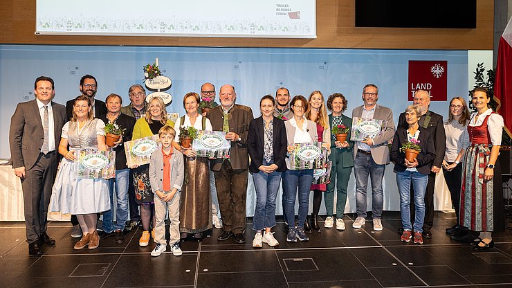 LR René Zumtobel (1.v.li.), Obfrau des Tiroler Bildungsforum Bettina Ellinger (1.v.re.) und Matthias Karader, Projektkoordinator Natur im Garten (2.v.li.), GemeindevertreterInnen und Natur im Garten BeraterInnen des Tiroler Bildungsforum mit Geehrten aus dem Bezirk Kitzbühel.