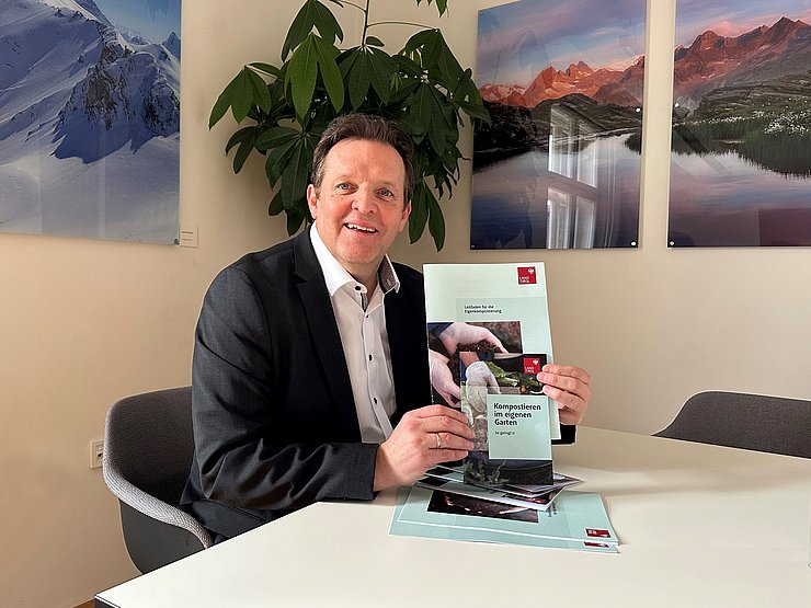 Zumtobel hält Broschüre in die Kamera