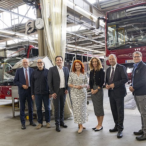 Gruppenfoto in Kfz-Werkstatt mit Bussen