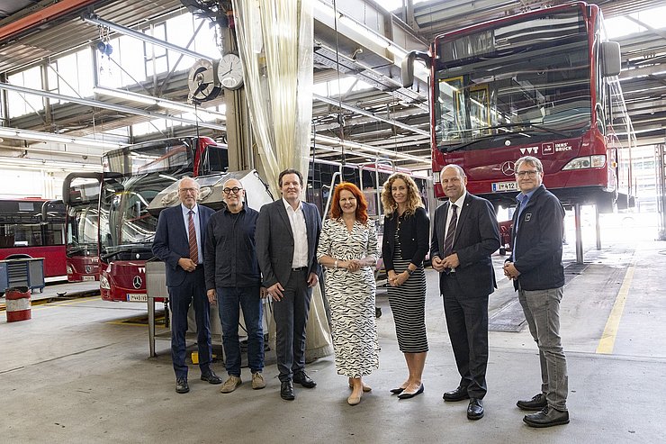 Gruppenfoto in Kfz-Werkstatt mit Bussen
