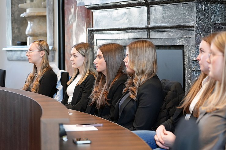 © Land Tirol/Neuner Mehrere junge Frauen sitzen im Landtagssaal auf einer Bank.
