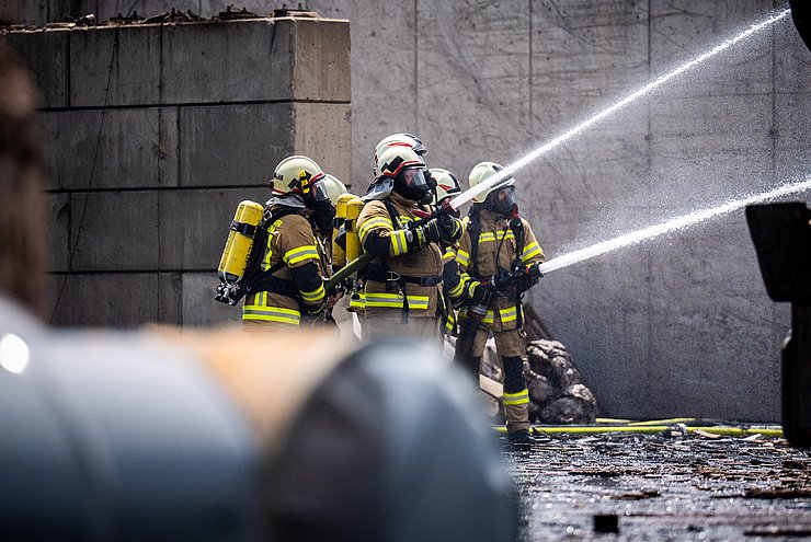 © Land Tirol/Christanell Im Bild: Vier Feuerwehrleute die einen Brand löschen auf einem Recycling-Areal. Knapp 1.000 Einsatzkräfte waren innerhalb der vier Tage beim Großbrand im Einsatz.