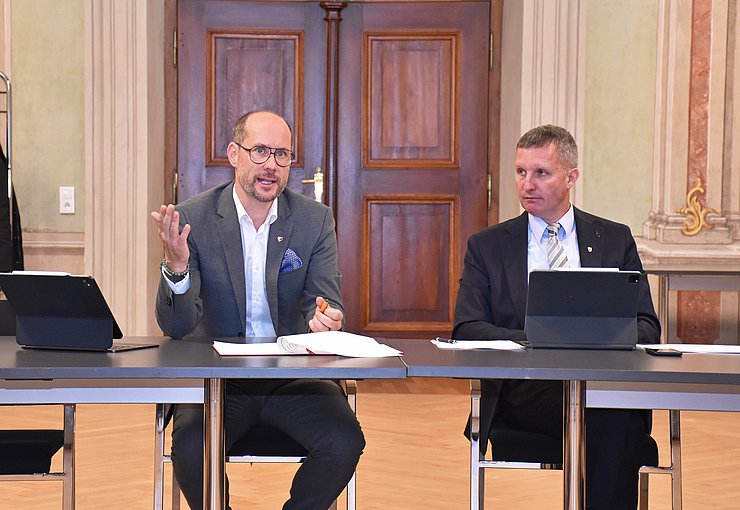 © Land Tirol/Pichler LR Gerber spricht sitzend hinter einem Tisch, LR Walcher sitzt daneben