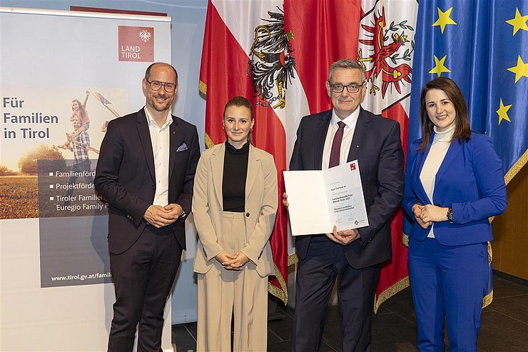 vier Personen mit Urkunde