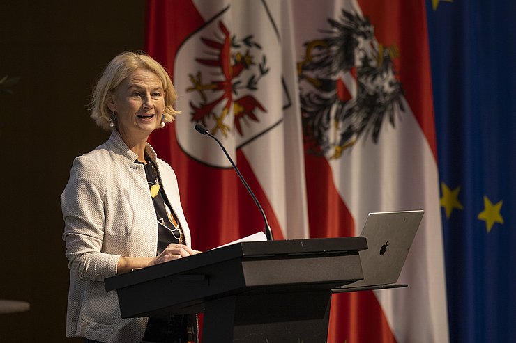 © Land Tirol/Die Fotografen Eine Frau steht an einem Rednerpult.