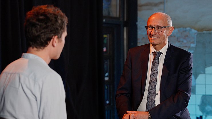 © Land Tirol Bühne mit zwei Stühlen auf denen LH Mattle und Kaschka sitzen und reden