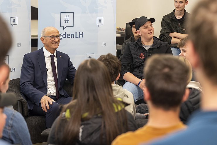 Mehrere Menschen sitzen nebeneinander.