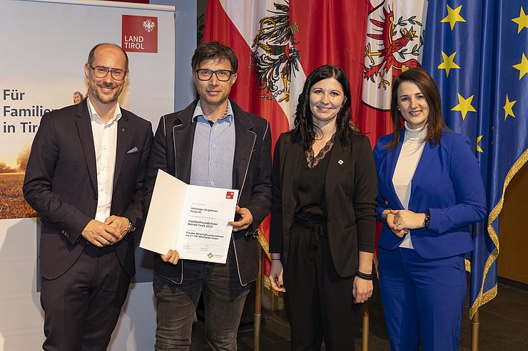 vier Personen mit Urkunde