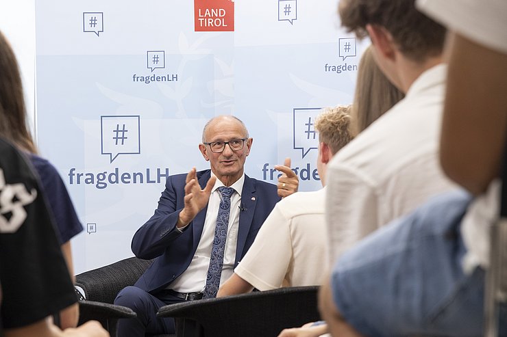 Ein Mann spricht zu mehreren jungen Menschen.