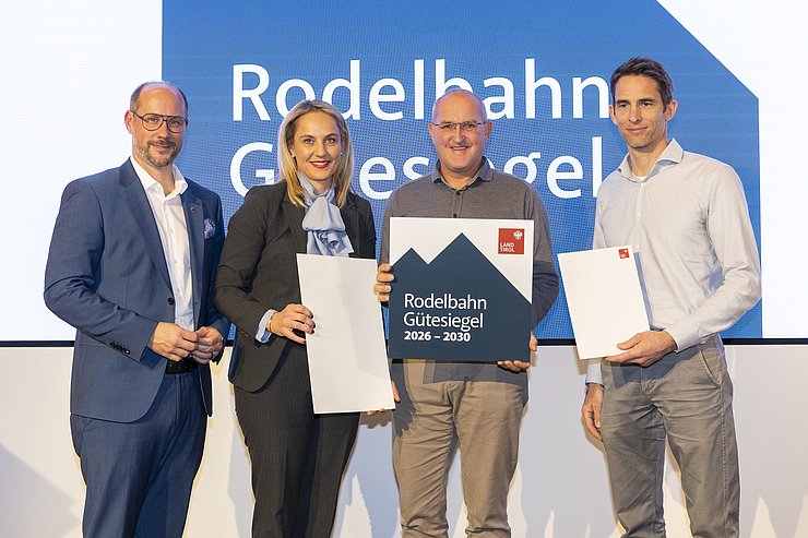 Vier Menschen sind bei einem Gruppenbild zu sehen.