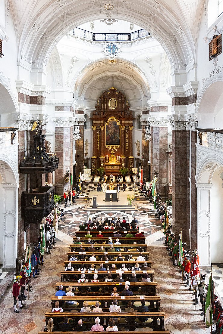 © Land Tirol/Die Fotografen Kirche Übersicht - Traditionsverbände am Rande aufgereicht