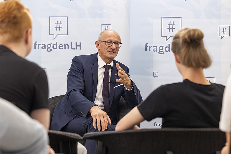 © Land Tirol/Die Fotografen Mehrere Menschen führen ein Gespräch.