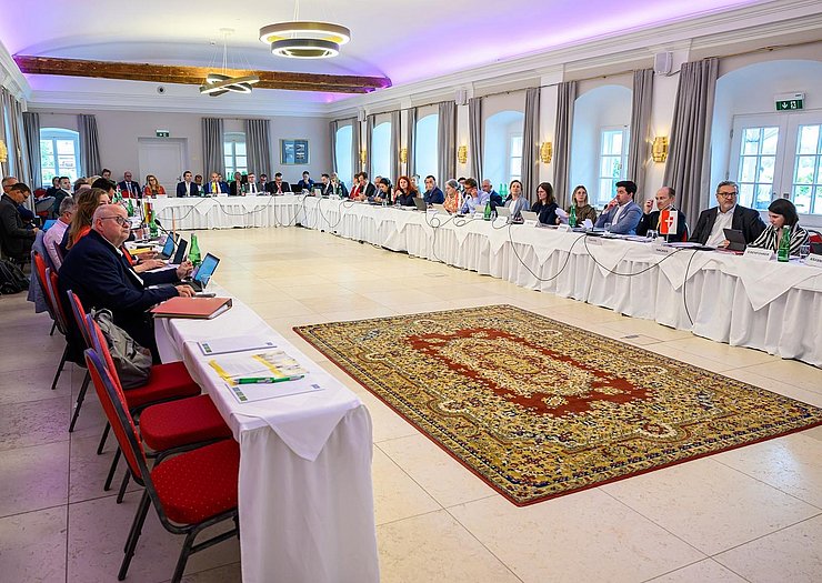 © NLK Burchhart Raum mit U-förmigem Tisch, an dem Personen sitzen