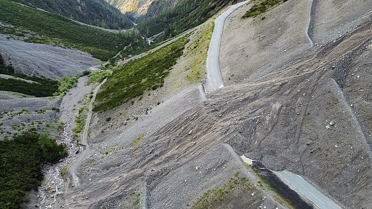 Auf dem Bild ist die Hantennjochstraße zu sehen. Eine Steinlawine bedeckt die Fahrbahn.