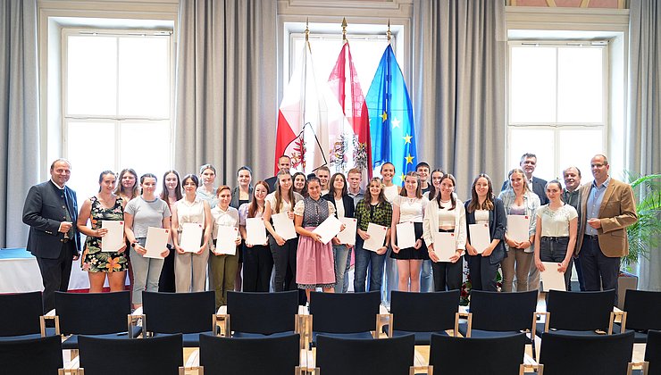 Gruppenbild von den 24 Anwesenden AbsolventInnen zusammen mit LHStv Josef Geisler und Prof. Lorenz Kohl.