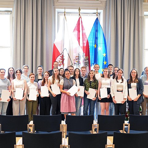 Gruppenbild von den 24 Anwesenden AbsolventInnen zusammen mit LHStv Josef Geisler und Prof. Lorenz Kohl.