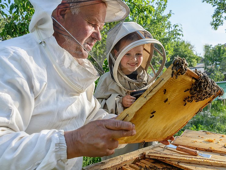 © Kosolovskyy/Shutterstock Imker und Kinder in Schutzkleidung