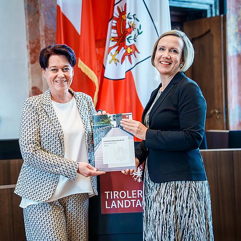 Landesvolksanwältin Doris Winkler-Hofer (re.) übergibt Landtagspräsidentin Sonja Ledl-Rossmann den Jahresbericht.