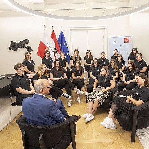 LH Anton Mattle sitzt vor den Jugendlichen und beantwortet ihre Fragen