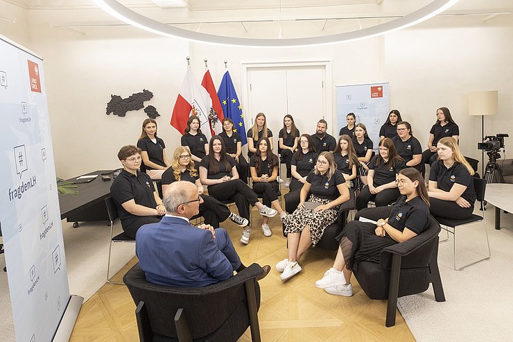 © Land Tirol/Die Fotografen LH Anton Mattle sitzt vor den Jugendlichen und beantwortet ihre Fragen