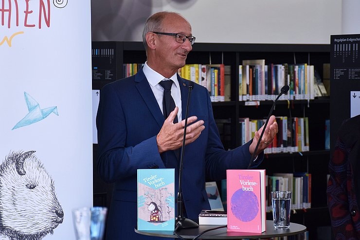 Der Landeshauptmann am Stehtisch mit zwei Büchern vor ihm