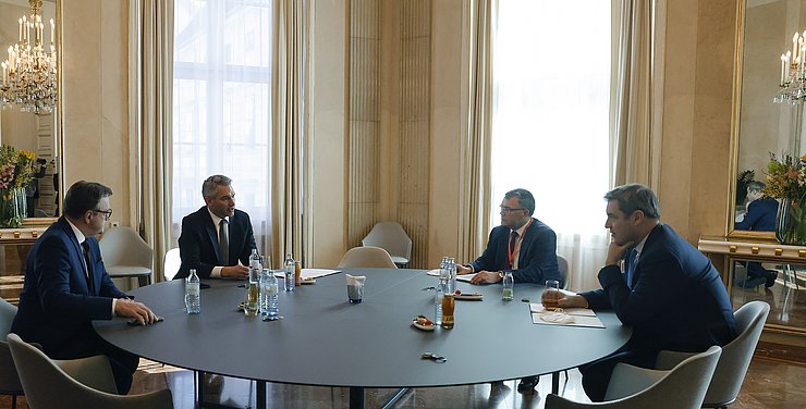 © Bundeskanzleramt/Dragan Tatic Platter, Nehammer, Herrmann und Söder sitzen an einem großen runden Tisch