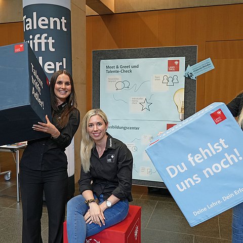 Mehrere Frauen halten Boxen in die Höhe.