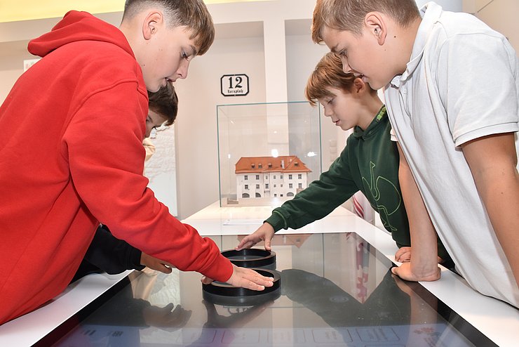 © Land Tirol/Sidon Schüler bewegen sich mit interaktiven Steuerungsringen am „Tangible“ durch die Euregio-Länder und testen im Quiz ihr Wissen.