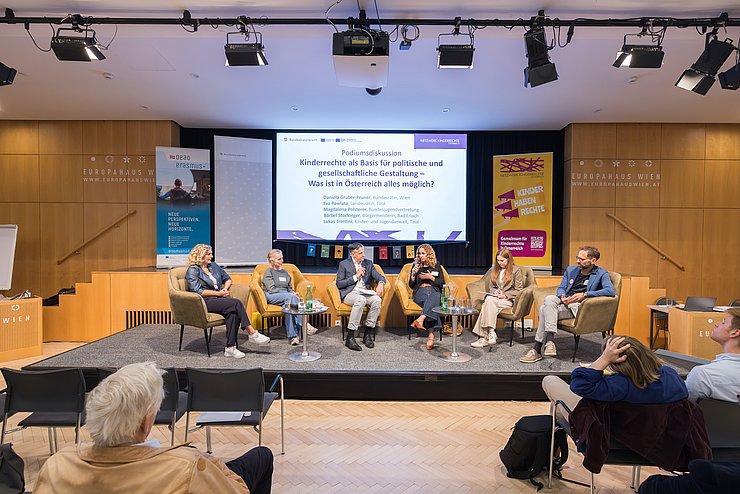 Personen sitzen auf Bühne