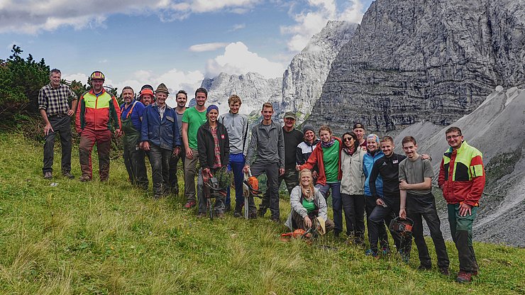 © NP Karwendel/Lukas Ascher Gruppenfoto auf der Alm mit Bergen im Hintergrund