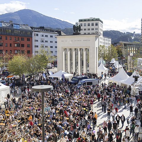 Blick auf den Landhausplatz von oben, wo viele Menschen sind.