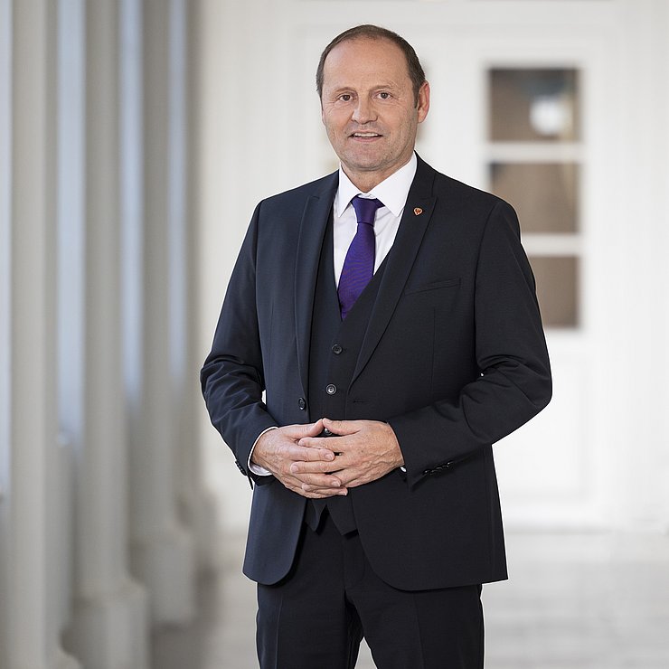 © Land Tirol/Die Fotografen LHStv Josef Geisler steht in einem Gang des Landhauses in Innsbruck.