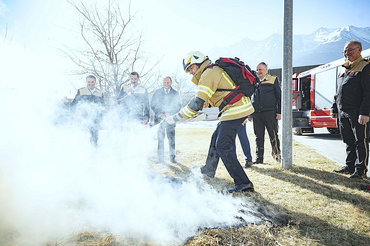 Feuerwehrmann Feuer auf Boden löschend, viel Rauch