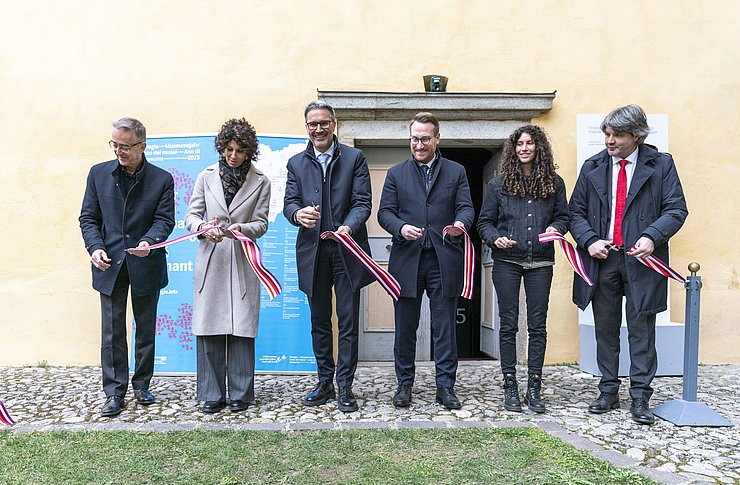 Mehrere Personen durchschneiden ein Band.