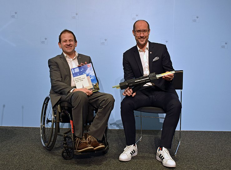 Rainer Seyrling hält Broschüre, Mario Gerber daneben mit Breitbandkabel